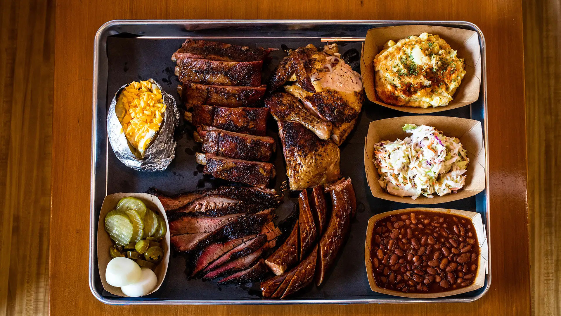 Family plate with ribs, brisket, sausage, chicken, and sides